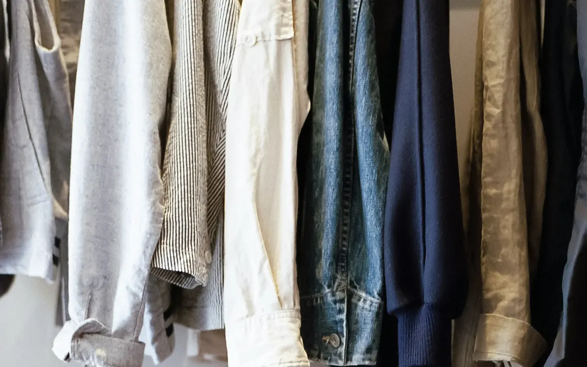 Roupa pendurada num roupeiro aberto