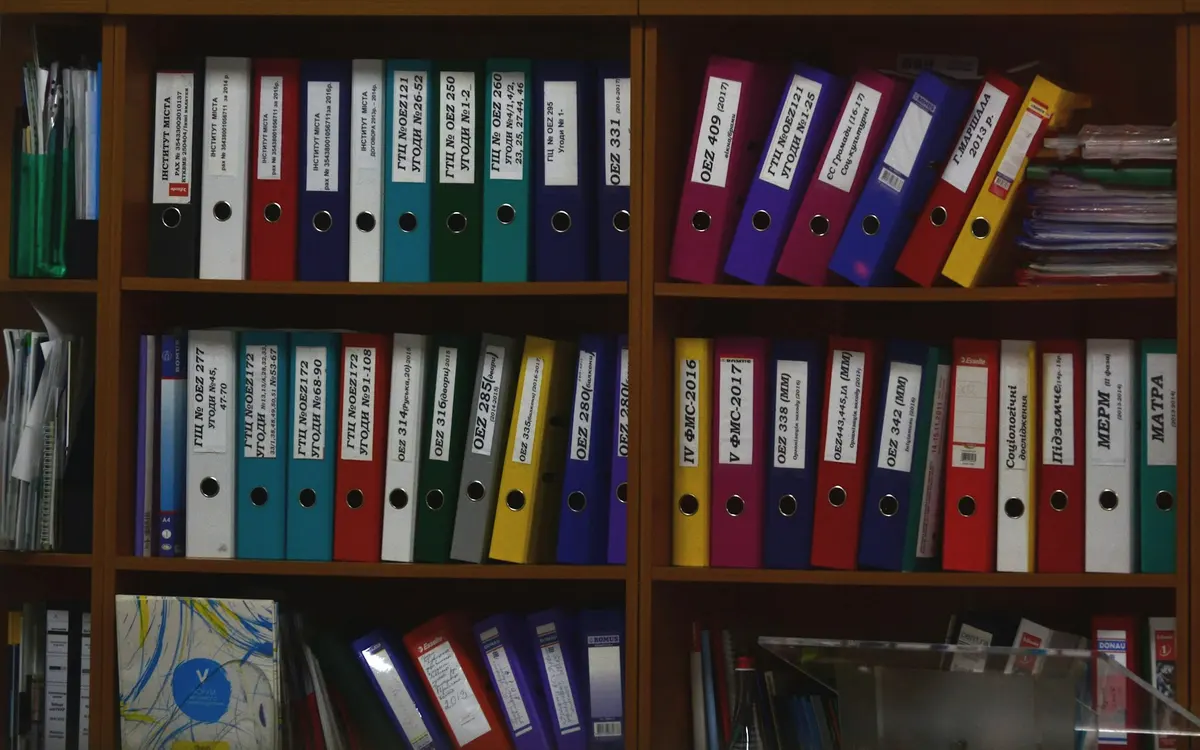 Dossiers coloridos organizados numa estante