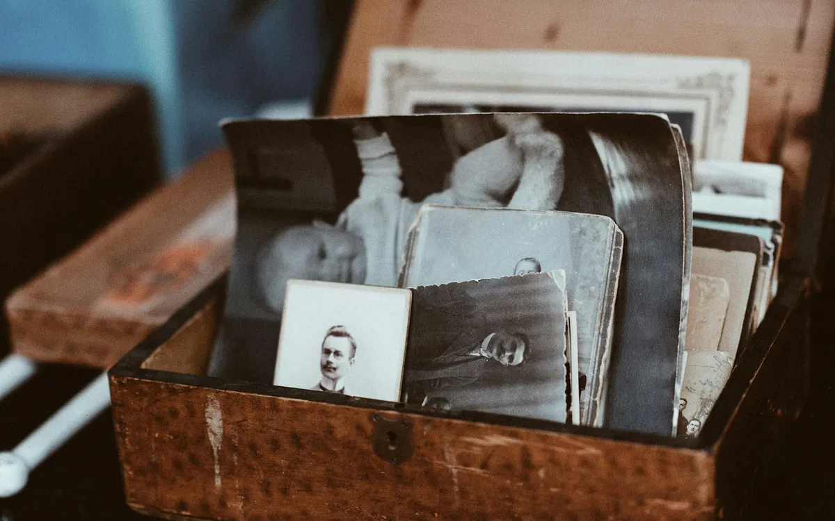 An old wooden case filled with black-and-white family photographs